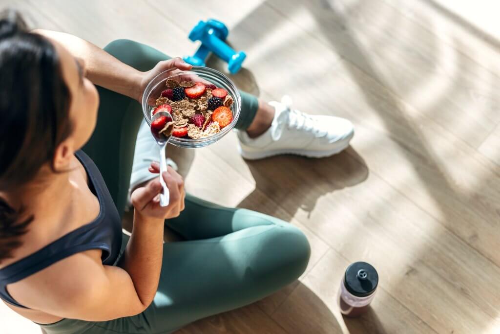 Woman taking a break from exercise to eat longevity foods